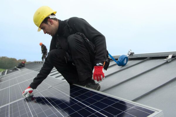 Worker using rail system for working at height to cleaning solar panel